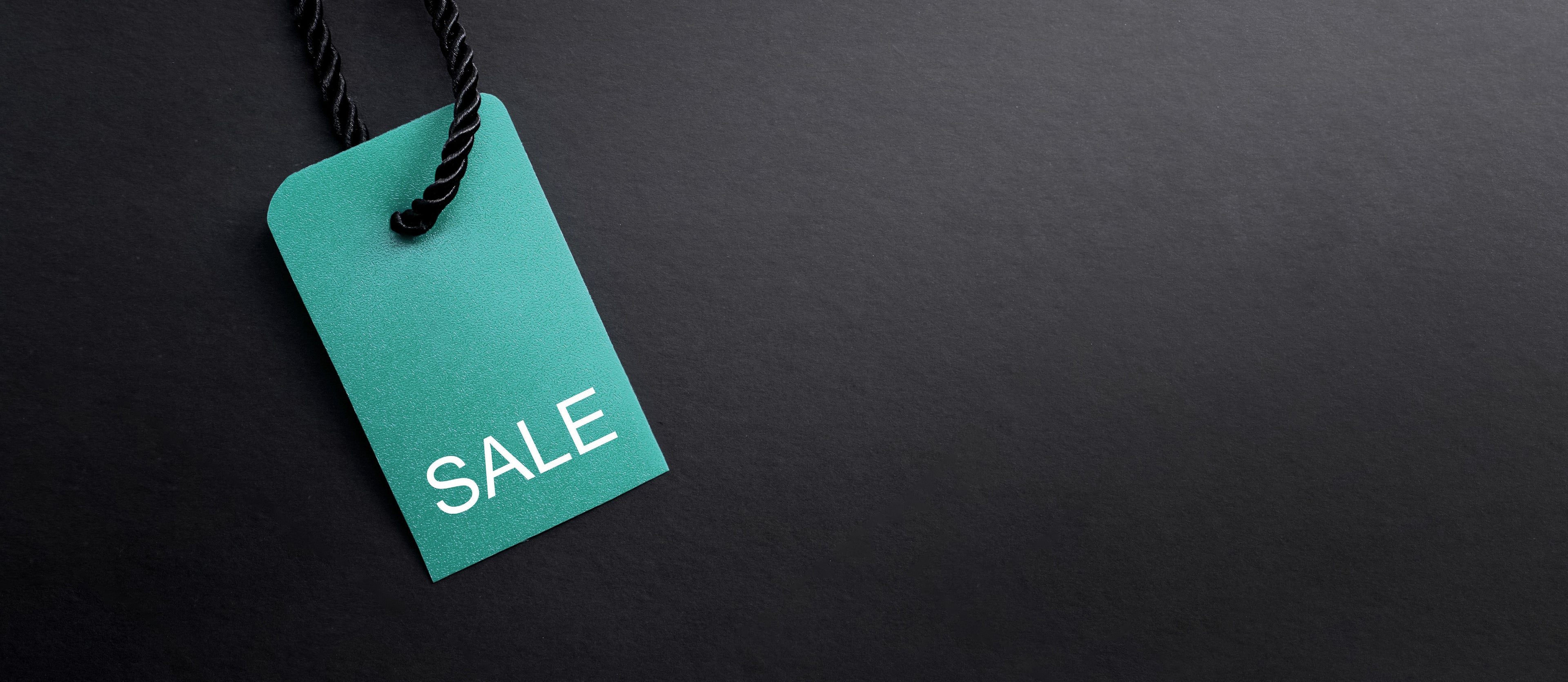 A blue sale tag on a black background.